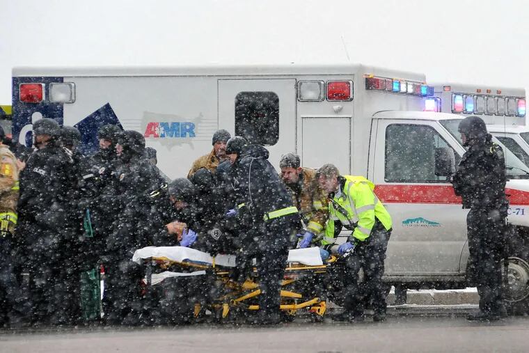 Emergency crews transport an officer to an ambulance in the heat of the siege at a Planned Parenthood clinic in Colorado Springs. The shooting lasted hours before officers persuaded the gunman to surrender.