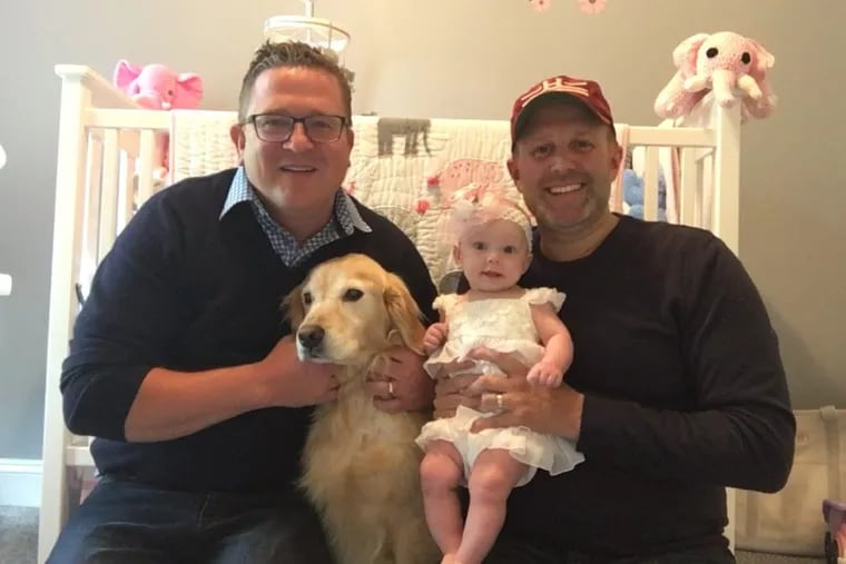Chris Urban (left), with dog Marshmellow, husband Joe Sena and baby Quinn.