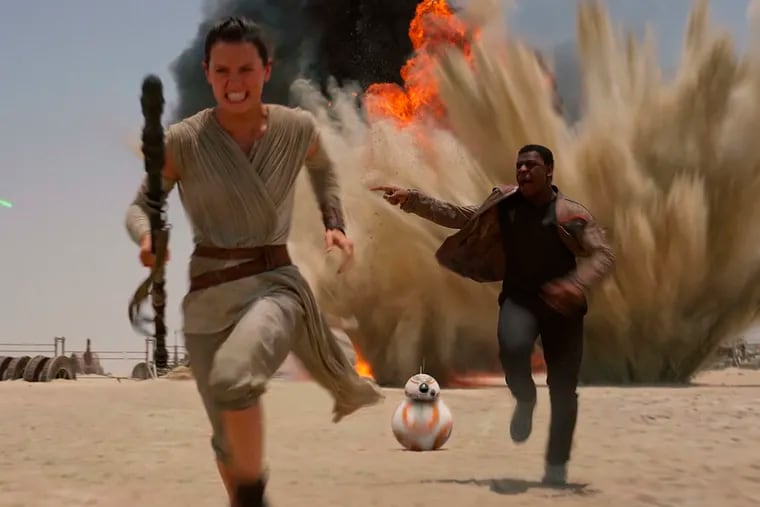 Daisey Ridley (left) and John Boyega in &quot;Star Wars: The Force Awakens,&quot; which set an opening-weekend record.