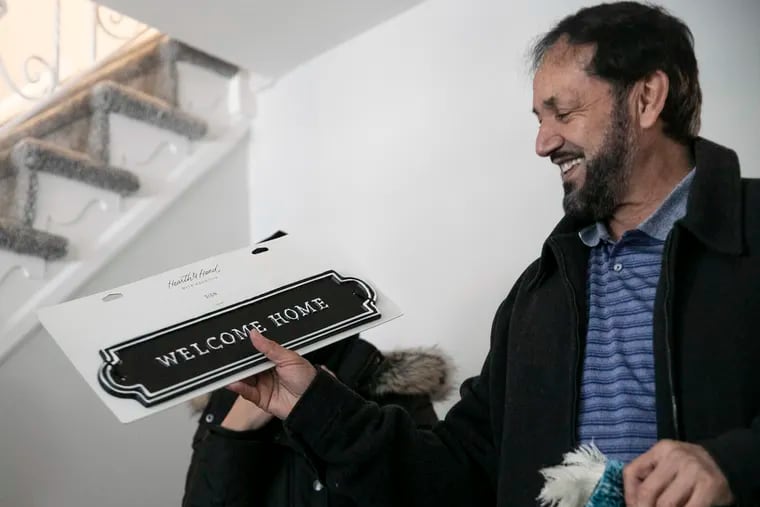 Sayed Mushtaq Muniri holds up a “Welcome Home” gift from Alexa Ragsdale in his family’s new Northeast Philadelphia home. Ragsdale turned over the Holmesburg rental house to the Muniri family, who recently arrived to the U.S. from Afghanistan. She plans to do the same for more families by starting a nonprofit organization, HeArt House.