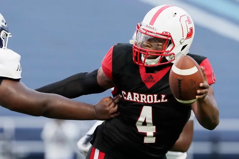 Archbishop Carroll quarterback Russel Minor-Shaw escaping the reach of a West Catholic player in the second quarter Saturday.