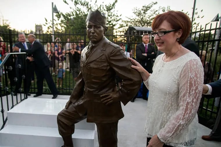Trisha Zavrel, daughter of Babe Heffron, with the statue of her “Band of Brothers” dad. (MEREDITH EDLOW/FOR THE DAILY NEWS)