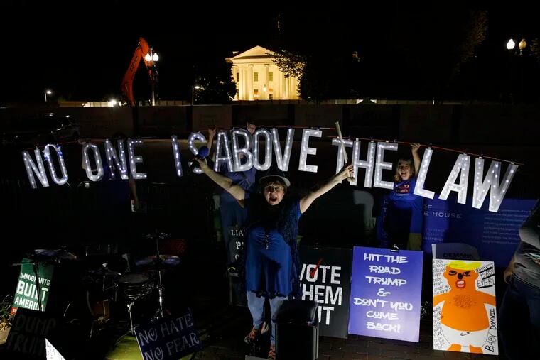 Protesters with Kremlin Annex with a light sign that reads "NO ONE IS ABOVE THE LAW" call to impeach President Donald Trump in Lafayette Square Park in front of the White House in Washington, Thursday, Sept. 26, 2019.