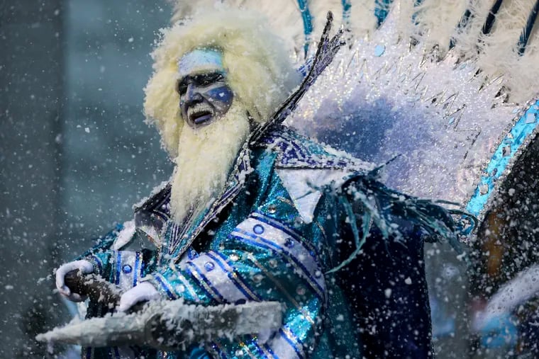 The Captain of the Ferko String Band, Anthony Celenza, performs “Freeze The Day!” as fake snow falls during the 2023 Mummers Parade.