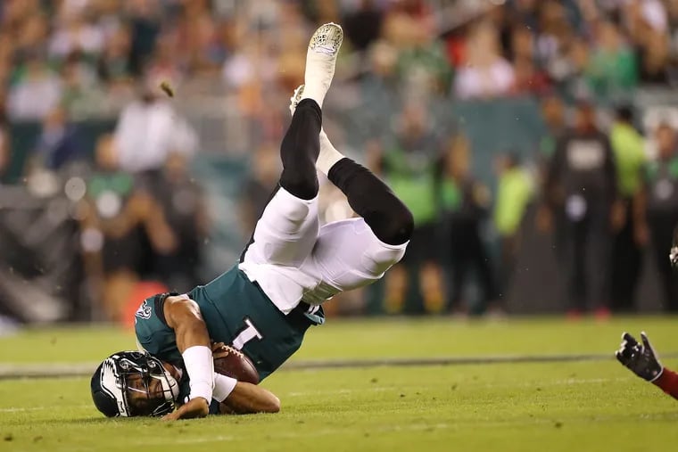 Eagles quarterback Jalen Hurts is tripped up on a run in the first quarter against the Buccaneers.