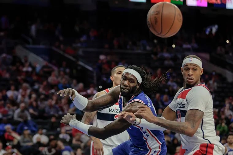 Sixers Montrezl Harrell drives to the basket for the loose ball between Wizards Kyle Kuzma left and Daniel Gafford during the 2nd quarter at the Wells Fargo Center in Philadelphia, Wednesday,  November 2, 2022.