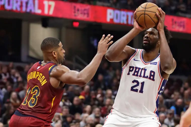 Joel Embiid (right) shoots over Cleveland's Tristan Thompson during the first half.