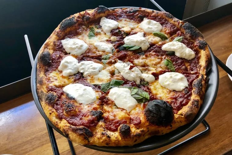 A Margherita pizza with roasted tomato sauce and creamy stracciatella cheese at Metropolitan  Cafe's new pizza oven.