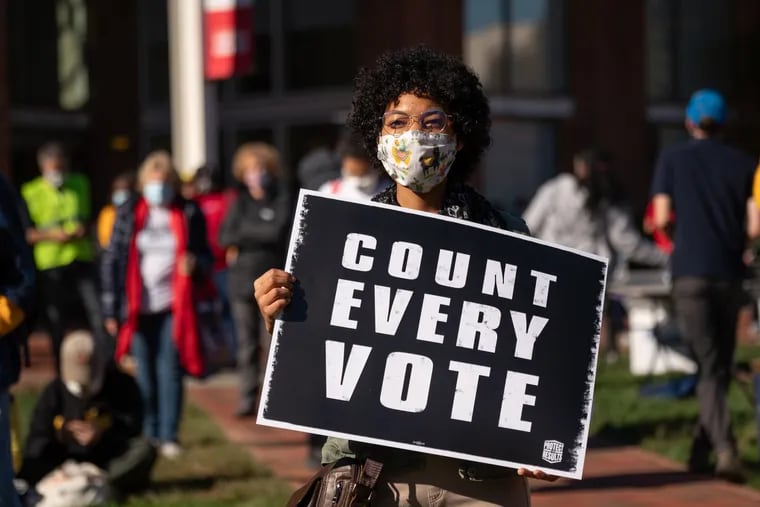 A voter holds a sign on the lawn in front of the Independence Visitors Center in Philadelphia as Joe Biden supporters rallied to ensure every vote was counted in the 2020 presidential election.