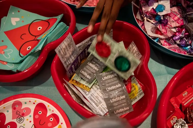 Teens grab condoms from a heart shaped bowl during an event hosted by Teen Health Week at the Mütter Museum on Tuesday, February 11, 2020. Students learned about sexual health and could get tested for STIs.