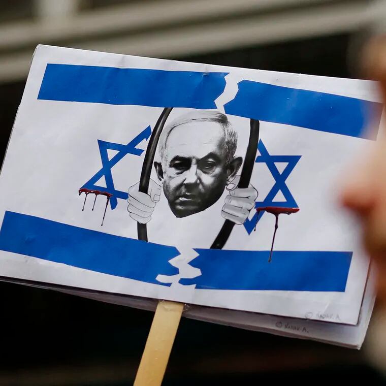 A picture of Israeli Prime Minister Benjamin Netanyahu behind bars is seen as members of the Israeli and Jewish communities gather to protest outside the Israeli Consulate in New York, March 27, 2023, during an emergency rally for Israeli democracy.