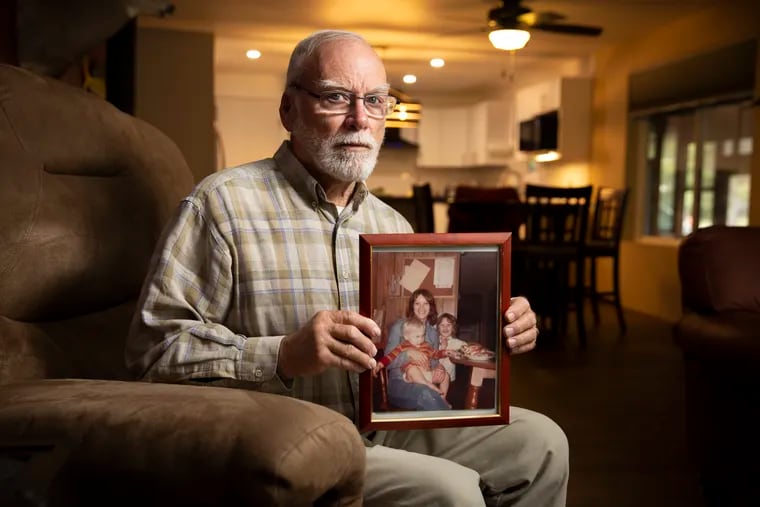 Charlie Hibbs holds a 1979 family photo of his wife, Joy, and their kids, Angie and David. Joy Hibbs' 1991 death remains one of Bucks County's most perplexing unsolved killings.