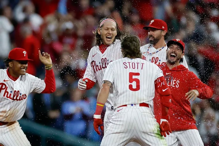 Phillies Alec Bohm celebrates with his teammates after getting the game winning extra innings RBI hit.