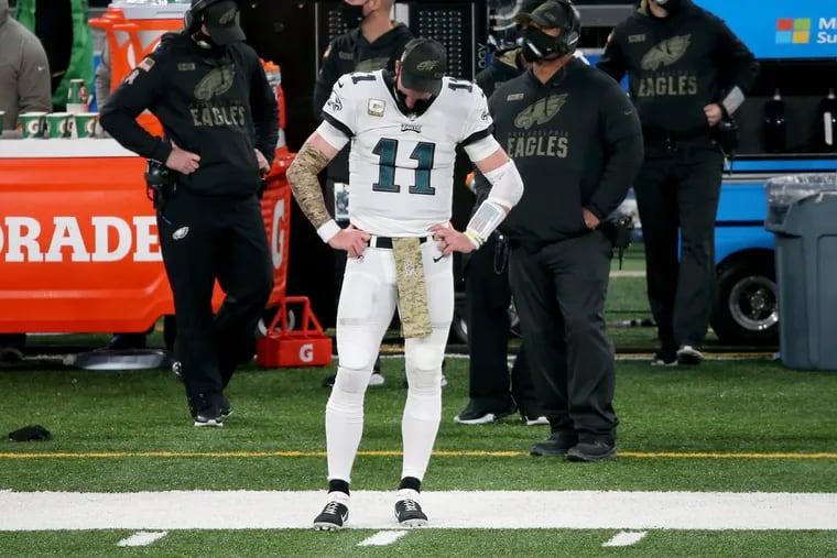 A dejected Carson Wentz watches from the sideline as time winds down in the game against the Giants.  The Philadelphia Eagles lose 27-17 to the New York Giants at MetLife Stadium in East Rutherford, N.J., on Sunday.