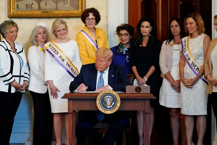 President Donald Trump signs a proclamation recognizing the 100th anniversary of the ratification of the 19th Amendment on Tuesday in the Blue Room of the White House.