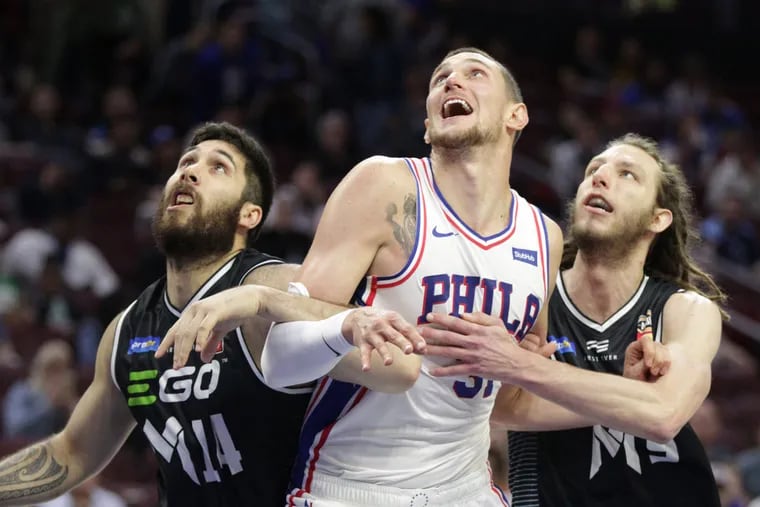 Mike Muscala, center, of the Sixers battles for rebounding position against Tohi Smith-Milner, left, and Craig Moller, right of Melbourne United in a exhibition game at the Wells Fargo Center on Sept. 28, 2018.
