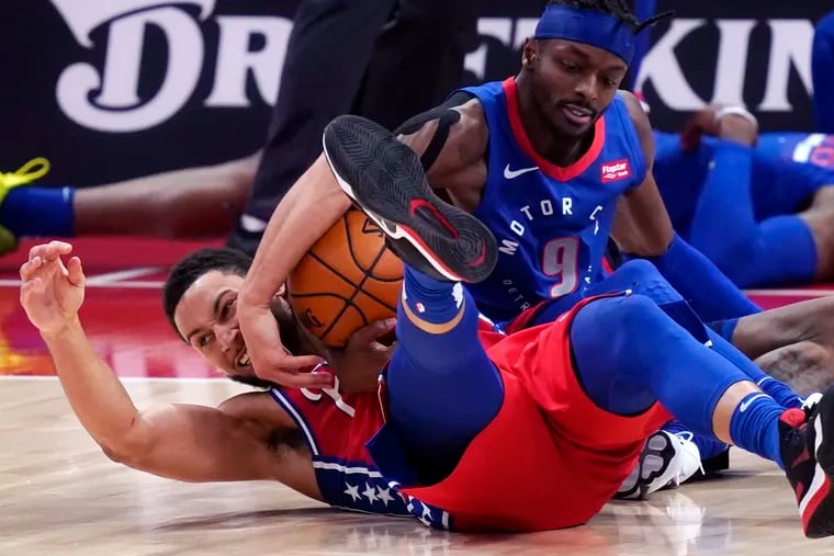 Sixers guard Ben Simmons and Detroit Pistons forward Jerami Grant battle for the loose ball during the second half of an NBA basketball game, Saturday.