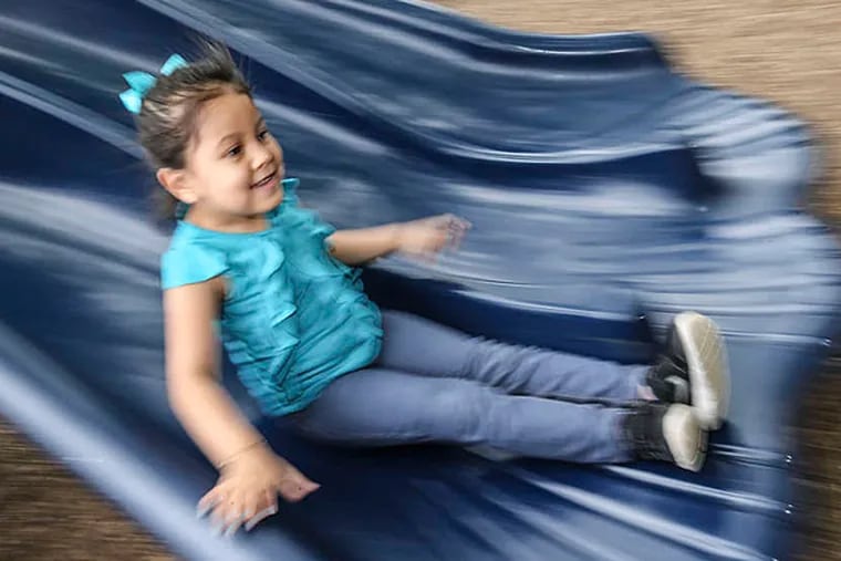 Danna Jimenez, 5, zooms down the slide. Much of the playground equipment was assembled by volunteers. (Steven M. Falk/Staff)