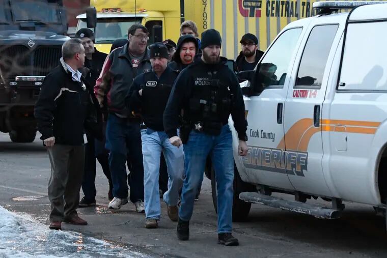 Employees are escorted from the scene of a shooting at a manufacturing company, Friday, Feb. 15, 2019, in Aurora, Ill, that police said left several people dead and several police officers wounded.
