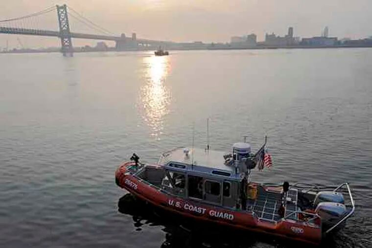 A Coast Guard boat cruises the Delaware River at Penn's Landing near where the barge struck Duck 34 the day before.