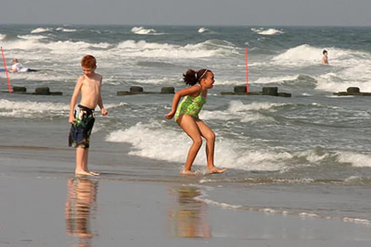 Children bravely play in the ocean at 23rd street and the beach in North Wildwood Thursday with water temperatures averaging just 62 degrees. (Jen Arthur / For the Inquirer)