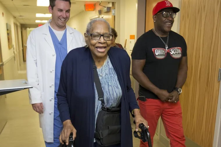 Betty Bell, center, walks through the hallway during a recent visit to the Einstein Center for Advanced Heart Failure, with Program Coordinator Tim Robbins and her son Kevin Bell.