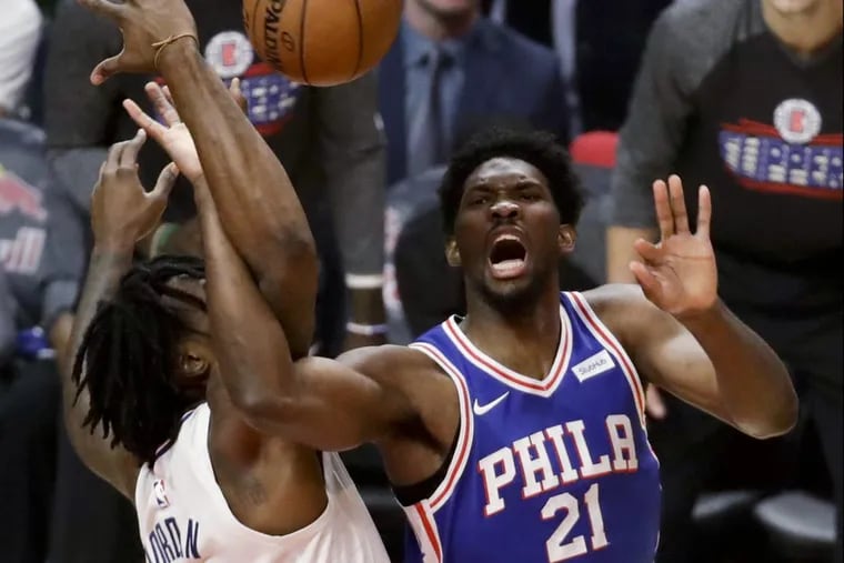 Joel Embiid, right, is fouled by Clippers center DeAndre Jordan during the first half of the Sixers’ game against Los Angeles Monday night.