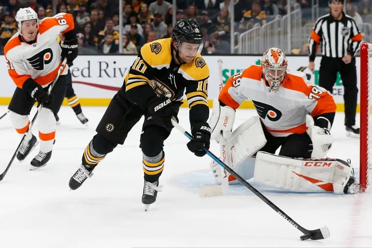 The Boston Bruins' Anders Bjork (10) controls the puck in front of Carter Hart (79) during the first period of the Flyers' 3-2 victory Sunday night at TD Garden.