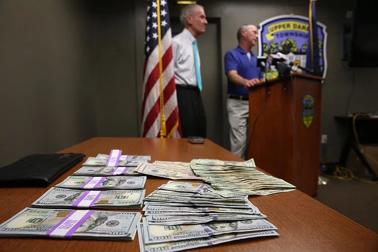 Bob Tracey (right); Upper Darby Police Superintendent Mike Chitwood; and the money.