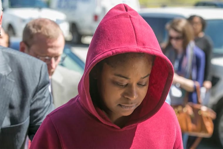 Police escort Cherie Amoore, 32, accused of kidnapping an infant at the King of Prussia Mall, from the District Courthouse in Upper Merion after her arraignment on Friday. Amoore claimed she had a newborn son who died in February.