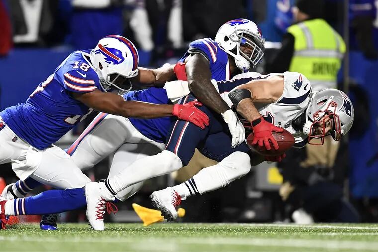 New England's Julian Edelman picks up a punt as Buffalo's Andre Holmes, left, and Ramon Humber tackle him down during the second half of the Patriots' 25-6 win over the Bills Monday night.