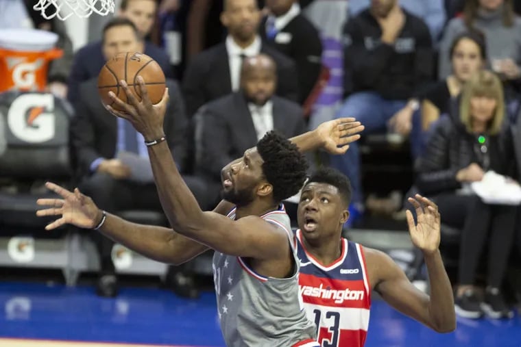 Sixers center Joel Embiid drives to the basket past Washington Wizards center Thomas Bryant during the first quarter on Friday.