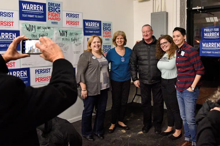 Mayor Jim Kenney poses with members of Sen. Elizabeth Warren's field office staff during the opening in West Philadelphia in January. The city's charter allows elected officials to volunteer on campaigns but prohibits most of the city's 25,000-person workforce from doing so.