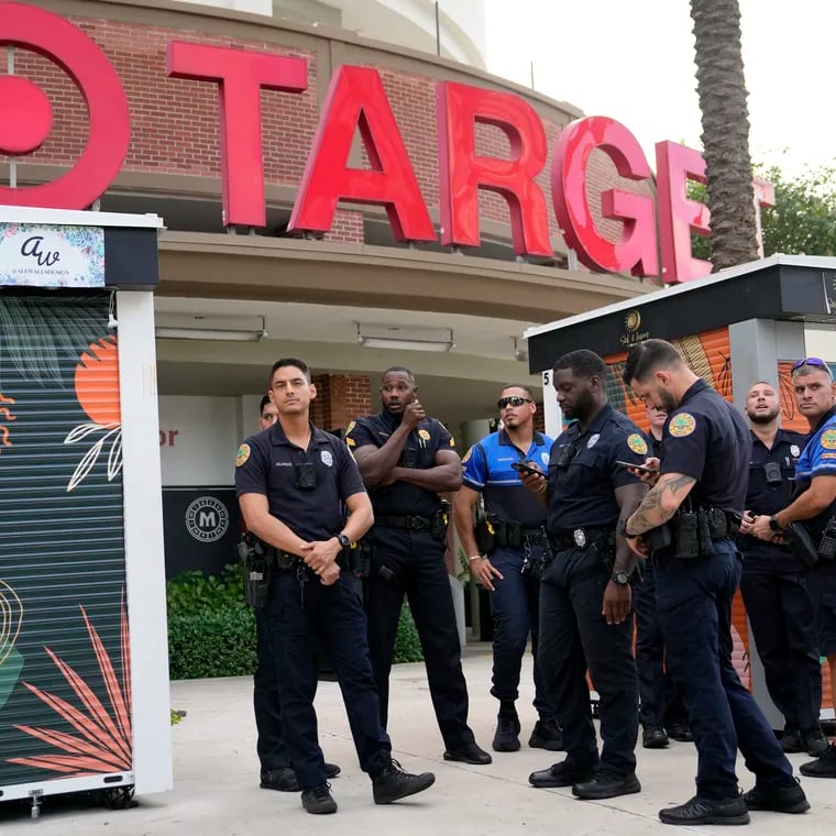 Police officers stand outside of a Target store as a group of people across the street protest against Pride displays in the store on June 1, 2023, in Miami. Target confirmed that it won't be carrying its LGBTQ+ merchandise for Pride month in June, 2024, in some stores after the discount retailer received backlash last year for its assortment.