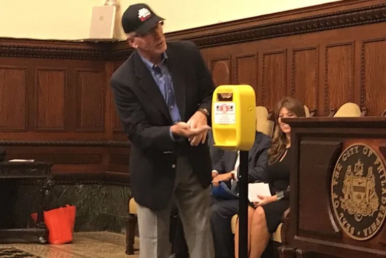 Phillies Hall of Famer Mike Schmidt demonstrates Philadelphia’s new sunscreen dispensers at a City Hall news conference on May 25, 2017.