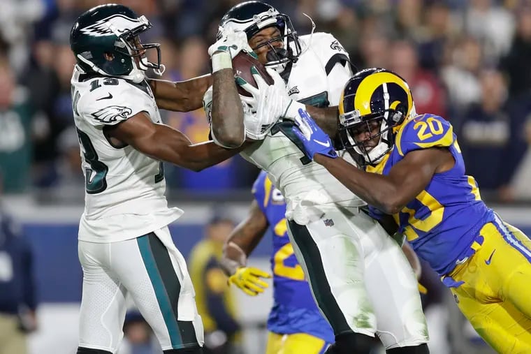 Eagles wide receiver Alshon Jeffery catches the football past teammate wide receiver Nelson Agholor against Los Angeles Rams free safety Lamarcus Joyner in the third-quarter on Sunday, December 16, 2018 in Los Angeles.  YONG KIM / Staff Photographer