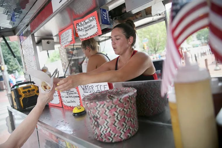 Lindsay Moffei, right, serves food at the Little Italy food stand at Sixth and Chestnut streets in Center City on Tuesday July 3, 2018. The city is in the middle of a heat wave.