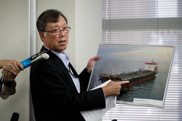 Yutaka Katada, president of Kokuka Sangyo Co., the Japanese company operating one of two oil tankers attacked near the Strait of Hormuz, shows a photo of the attacked oil tanker during a news conference Friday, June 14, 2019, in Tokyo.