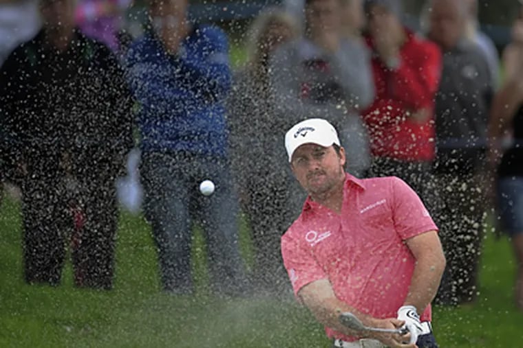 Graeme McDowell blasts the ball out of the bunker at the 18th hole during the third round of the Volvo Masters. (AP Photo/Alvaro Barrientos)