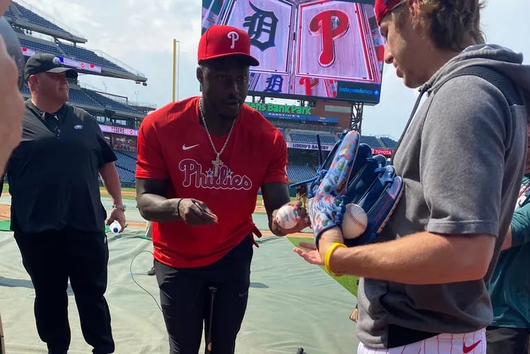Eagles receiver AJ. Brown signing an autograph for the Phillies' Bryson Stott.