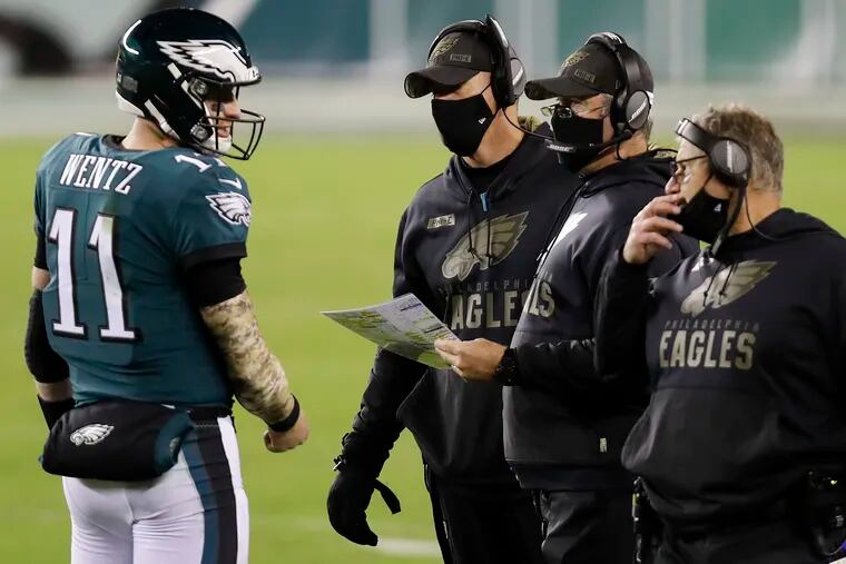 Eagles quarterback Carson Wentz committed four turnovers Sunday night against the Cowboys. It's unlikely coach Doug Pederson (middle right) will try to rein him in.