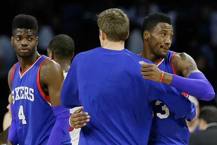 Detroit Pistons forward Jonas Jerebko, center, is hugged by Philadelphia 76ers forward Robert Covington after an NBA basketball game in Auburn Hills, Mich., Saturday, Dec. 6, 2014. The 76ers defeated the Pistons 108-101. (Carlos Osorio/AP)