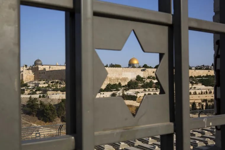 The Islamic Dome of the Rock in Jerusalem’s Old City is seen through a door decorated with a Jewish Star of David.