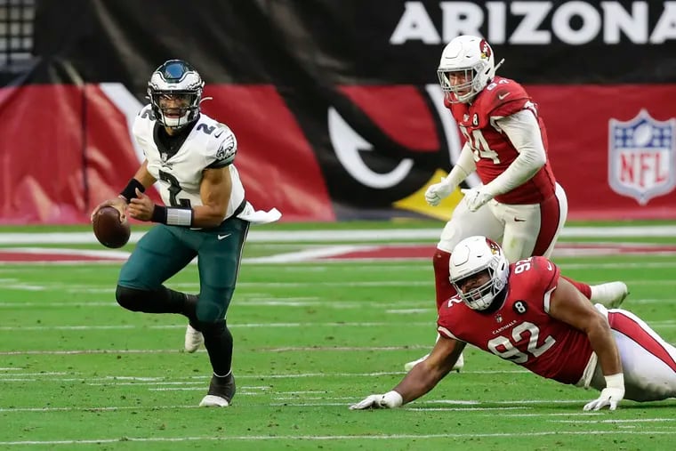 Eagles quarterback Jalen Hurts scrambles past Arizona Cardinals defensive tackle Rashard Lawrence (on ground) and defensive end Zach Allen in the second quarter.