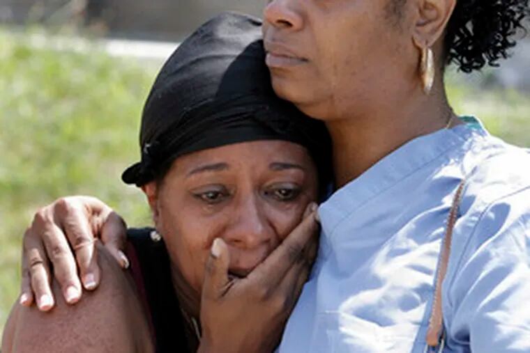 Vern Mack (right), a friend of Charles Tunstall, 23, who was shot to death at 54th and Arlington Streets in the Wynnefield section of the city, consoles a friend at Tunstall&#0039;s home.