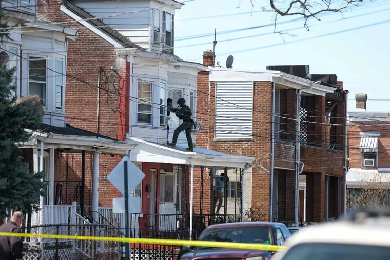 SWAT officers escort people out of a second story window from a residence in Trenton, N.J. on Saturday.