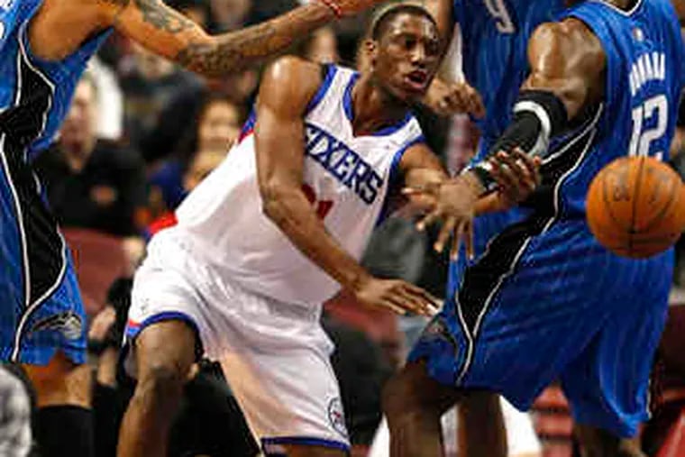 Sixers forward Thaddeus Young has no choice but to dish off after being trapped by the Magic's (from left) Matt Barnes, Rashard Lewis, and Dwight Howard at the Wachovia Center. Young finished with 17 points.