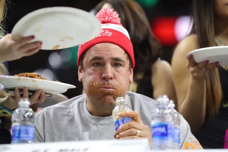 A speed-eater competes during the second round of Wing Bowl XXV at the Wells Fargo Center. Researchers warn that speed-eating can do more to the untrained than just add pounds, pushing the body beyond healthy limits.