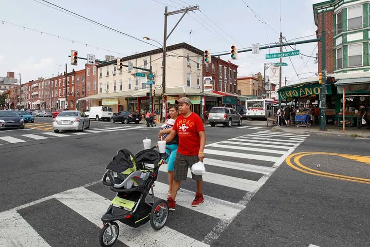 In this Inquirer file photo, people cross Washington Avenue at 9th Street. The city is asking residents to weigh in on three redesign plans it's considering ahead of a repaving project slated for Washington Avenue next year.