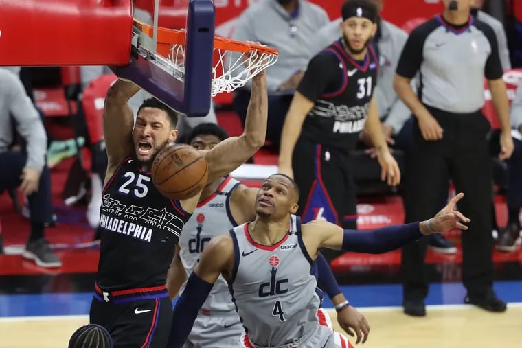 Ben Simmons of the SIxers dunks against Washington's Russell Westbrook in the first half Wednesday. Later, Westbrook was injured, and a fan dumped popcorn on his head as he exited the court.